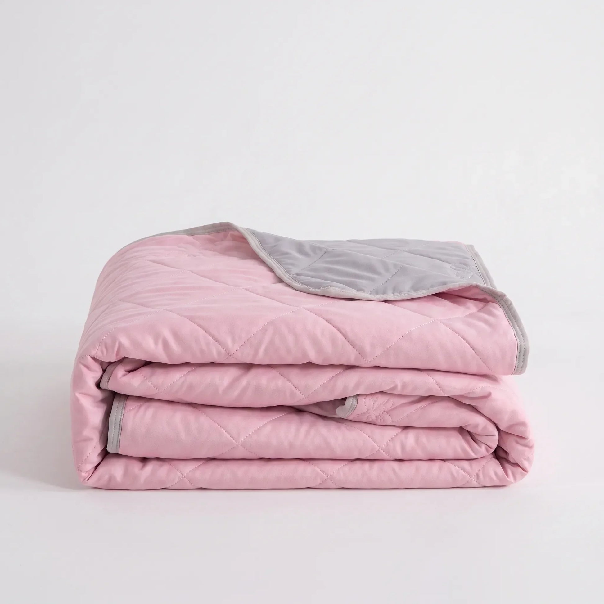 Lightweight cooling blanket draped over a bed