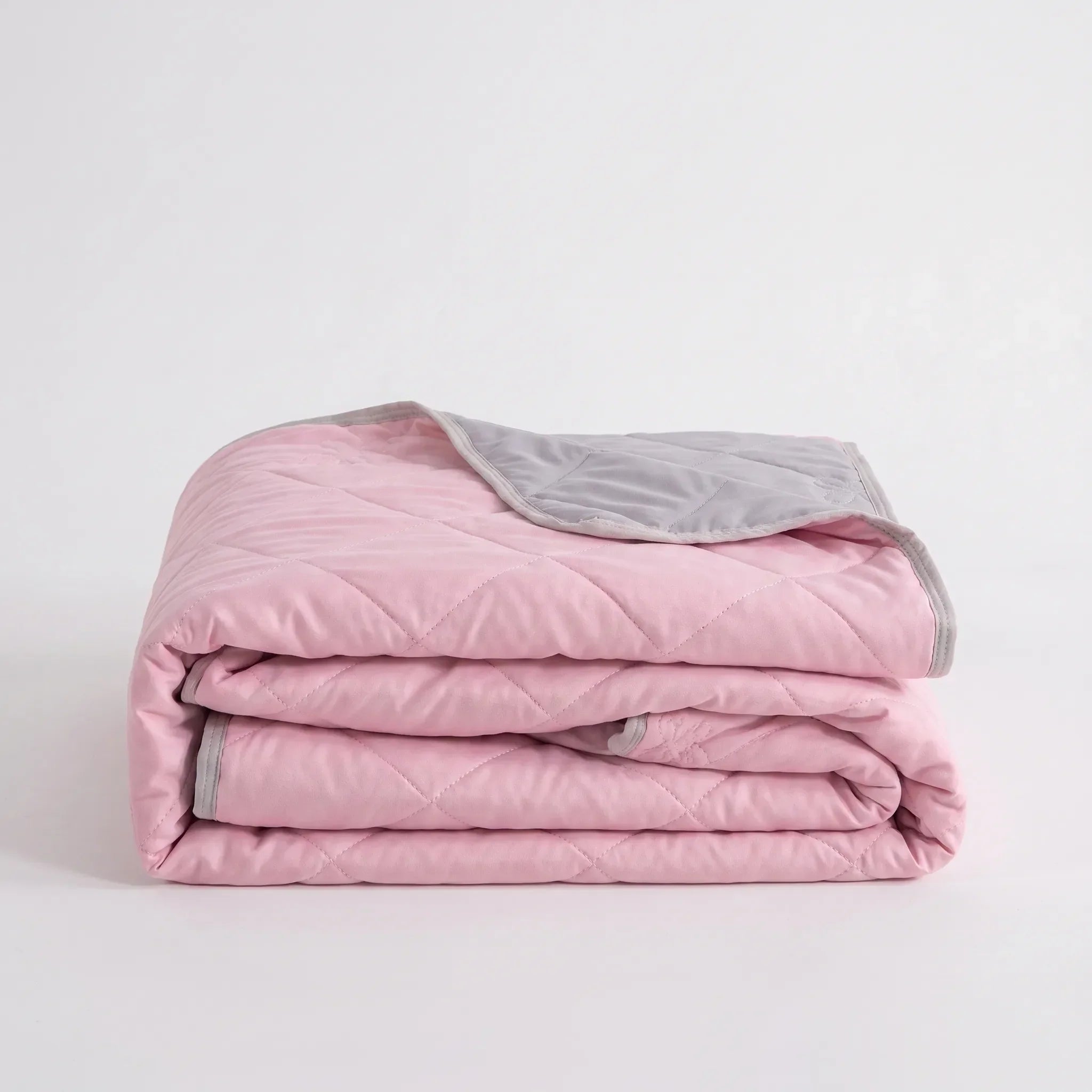 Lightweight cooling blanket draped over a bed